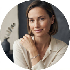 Portrait of Beatrice H. wearing a sterling silver Figaro link chain, shown in a clean, minimalist setting.